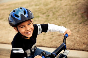 Back to school bike safety image of a boy riding his bike to school